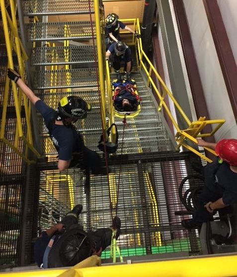 Three men training with safety equipment