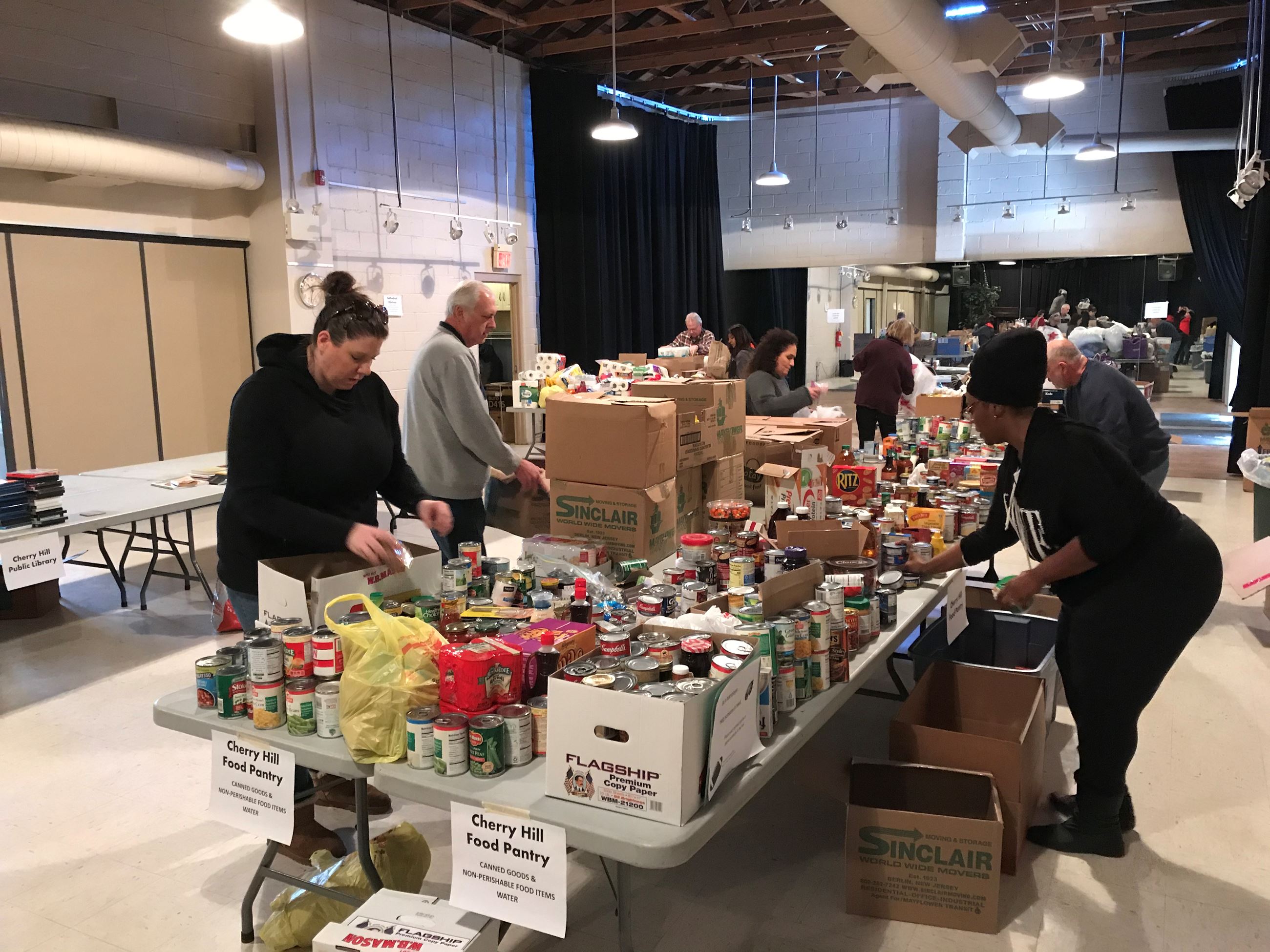 Volunteers at table laden with donations for food pantry
